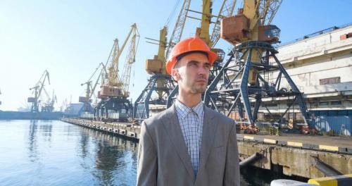 vecteezy_young-male-worker-of-sea-harbor-in-helmet-cargo-manager-in_7565579